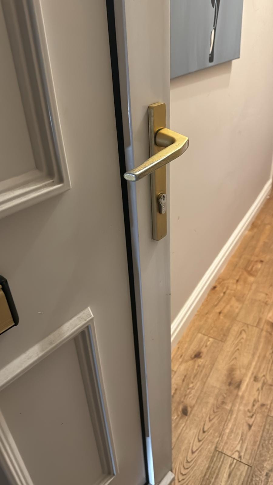 Gold uPVC handle freshly fitted on an internal door, screws driven and lever aligned.