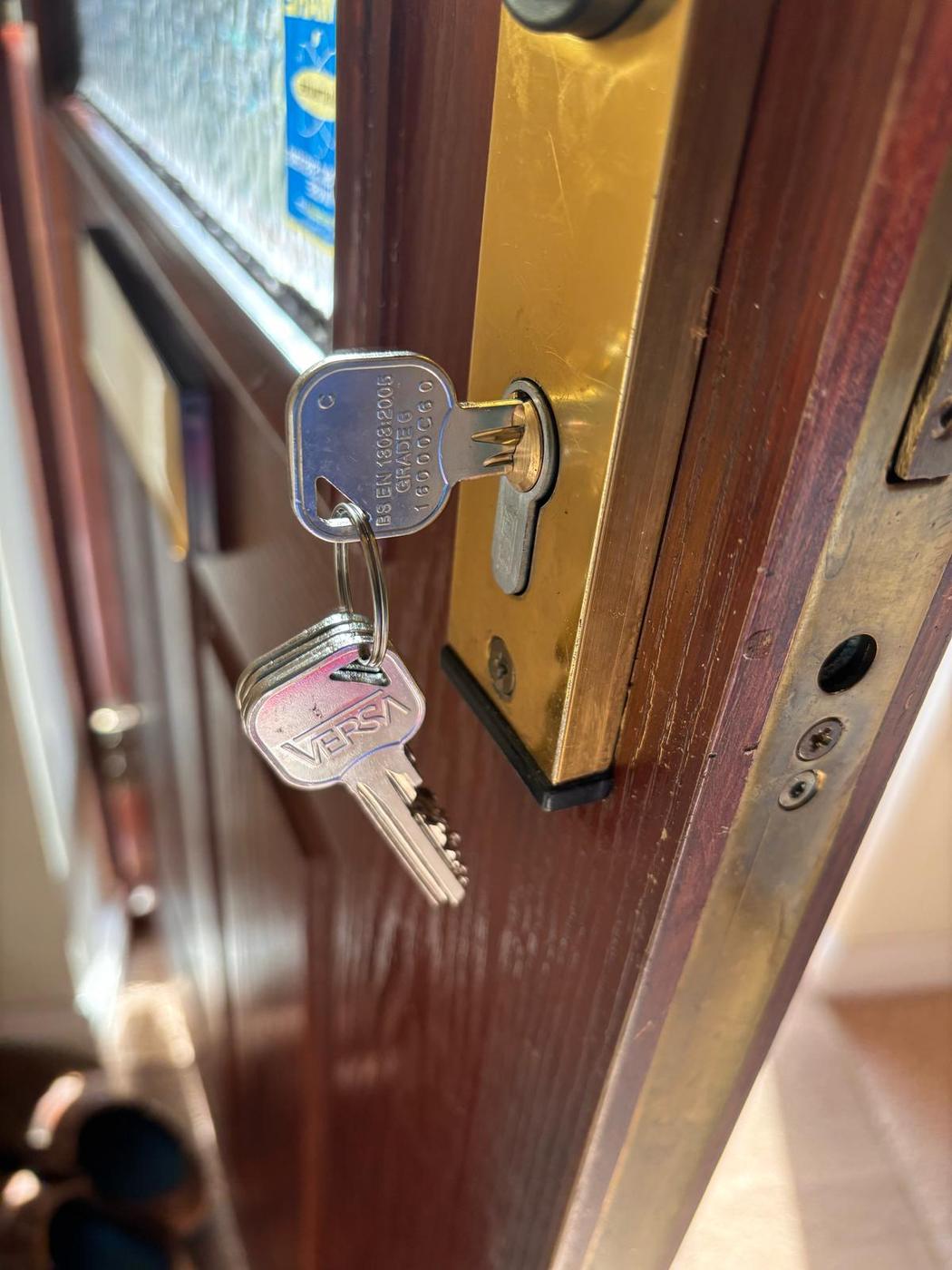 New brass key inserted in a cylinder labelled BS3621 GRADE 6 — British Standard approved lock fitted in Redditch.