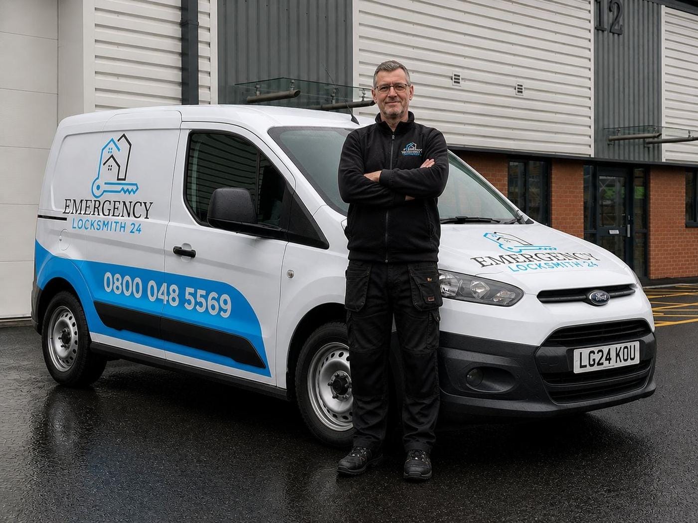 Emergency Locksmith 24 technician standing beside the branded service van — phone number 0800 048 5569 and company logo clearly visible — ready to dispatch across Redditch.